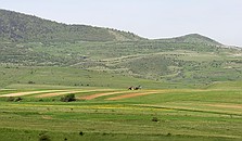 Mountains, fields, meadows and tractors near the village of Kalotaszentkiraly.